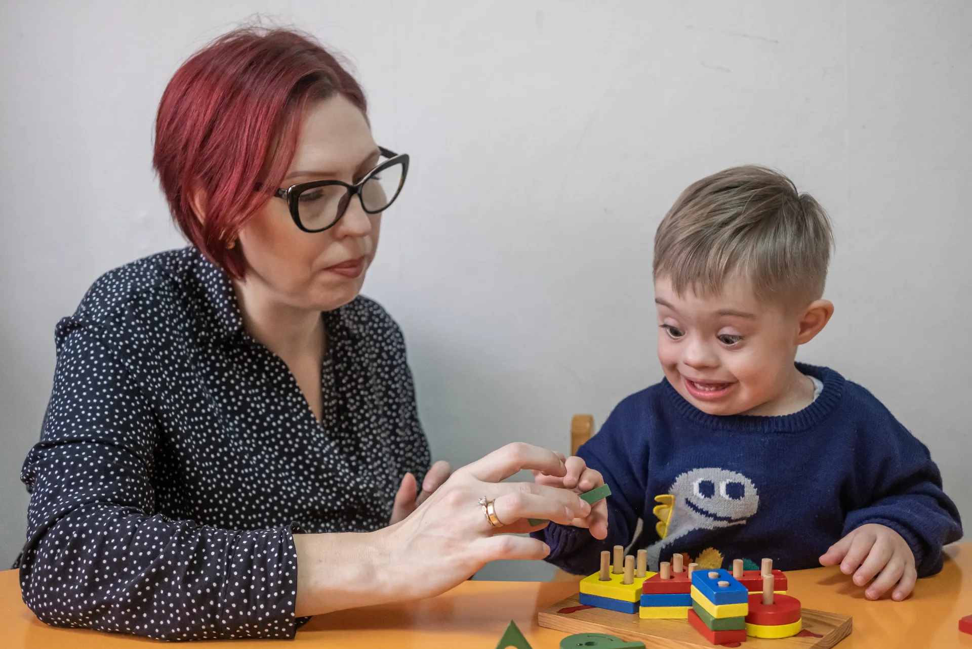 Cuidadora acompañando a un niño con discapacidad intelectual durante una sesión de juego